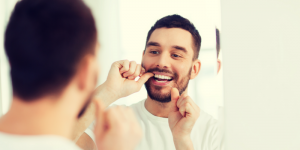 man flossing dental implants