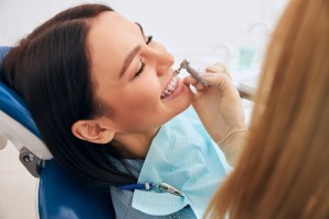 Woman getting her teeth cleaned and smiling